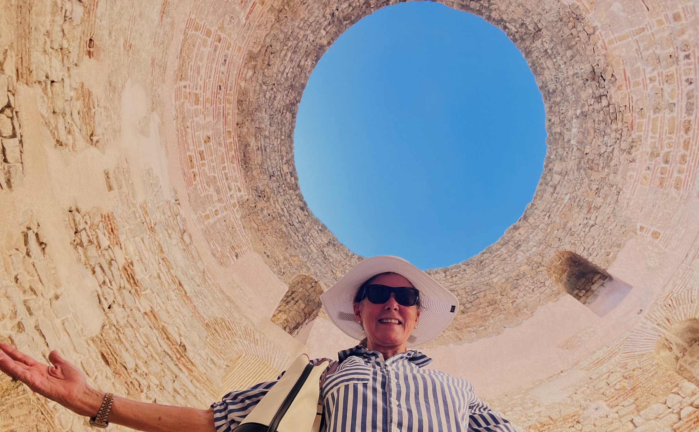 Opening to blue sky with Robin looking at the camera in Diocletian's Palace in Split Croatia